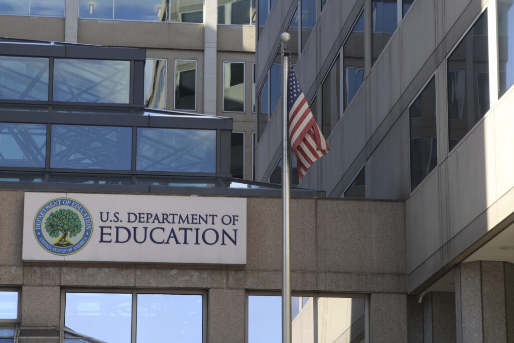 The U.S. Department of Education building with its entrance sign and an American flag