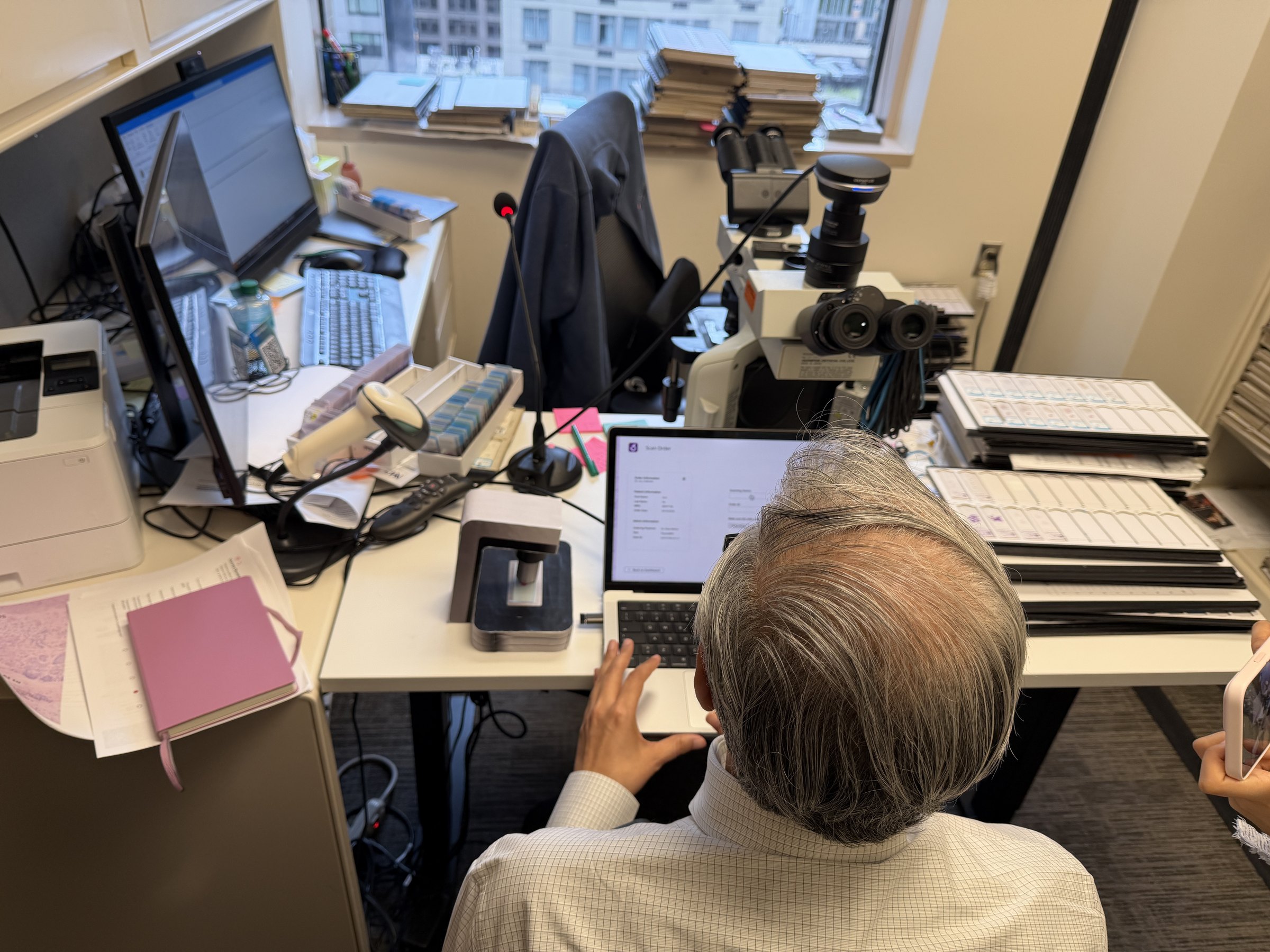 Pathologist working through the prototype at a microscopy workstation during a usability session